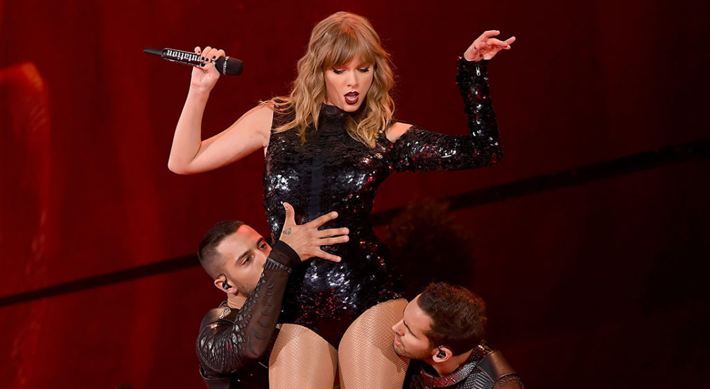 Taylor Swift removes cropped hoodie jacket to reveal one shouldered sequined bodysuit during Reputation Tour